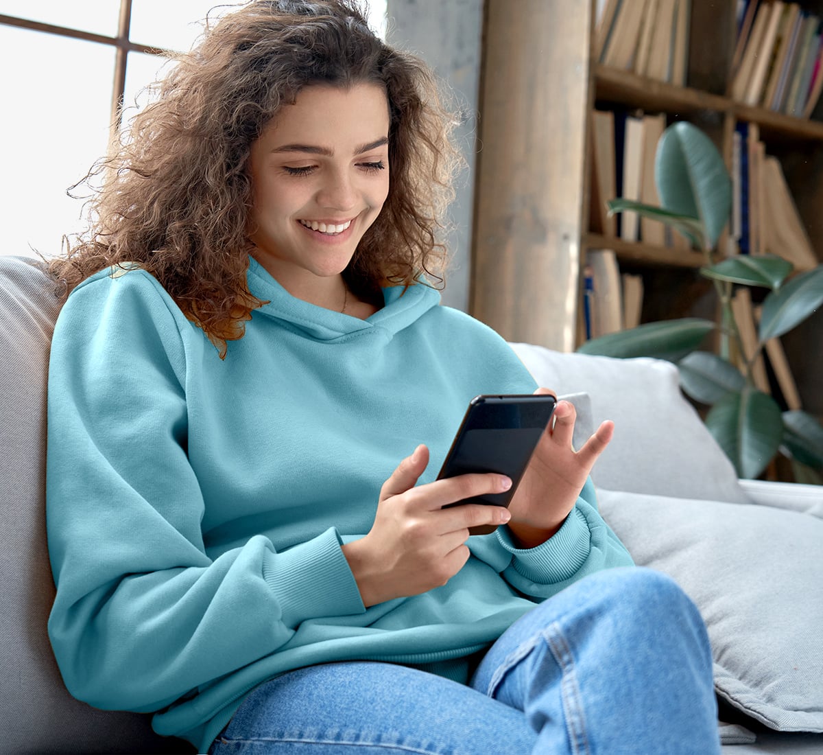 A girl looking at her phone and smiling