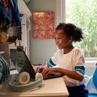 niña en la computadora con audífonos