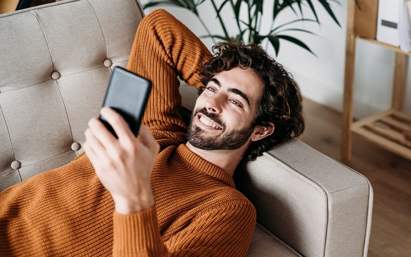 man looking at phone and smiling