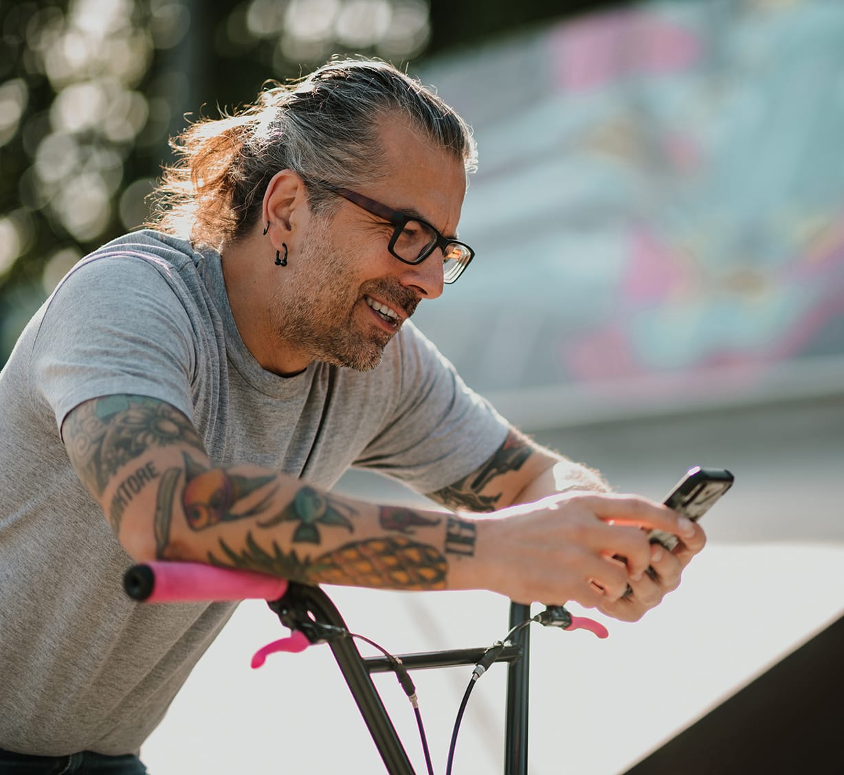 A man holding his mobile device while sitting on a bicycle