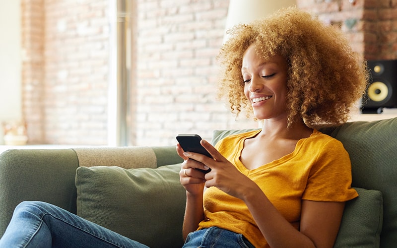 A woman seeing at her mobile happily