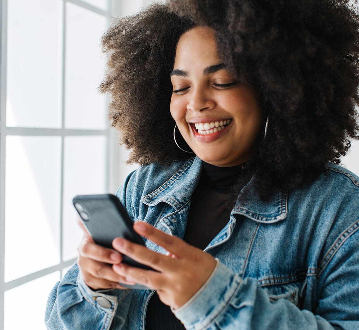 A woman looking at her mobile happily 