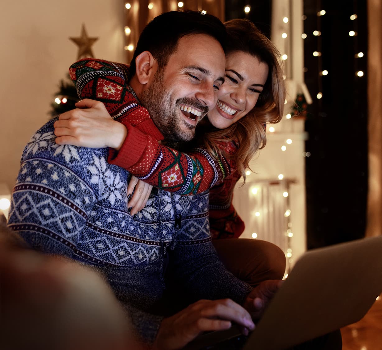 both men and women are laughing while watching laptop