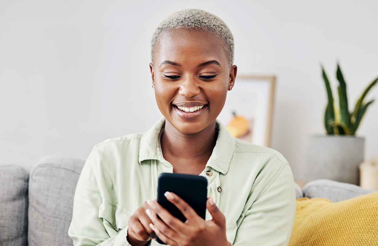 A women looking at her phone with a smile