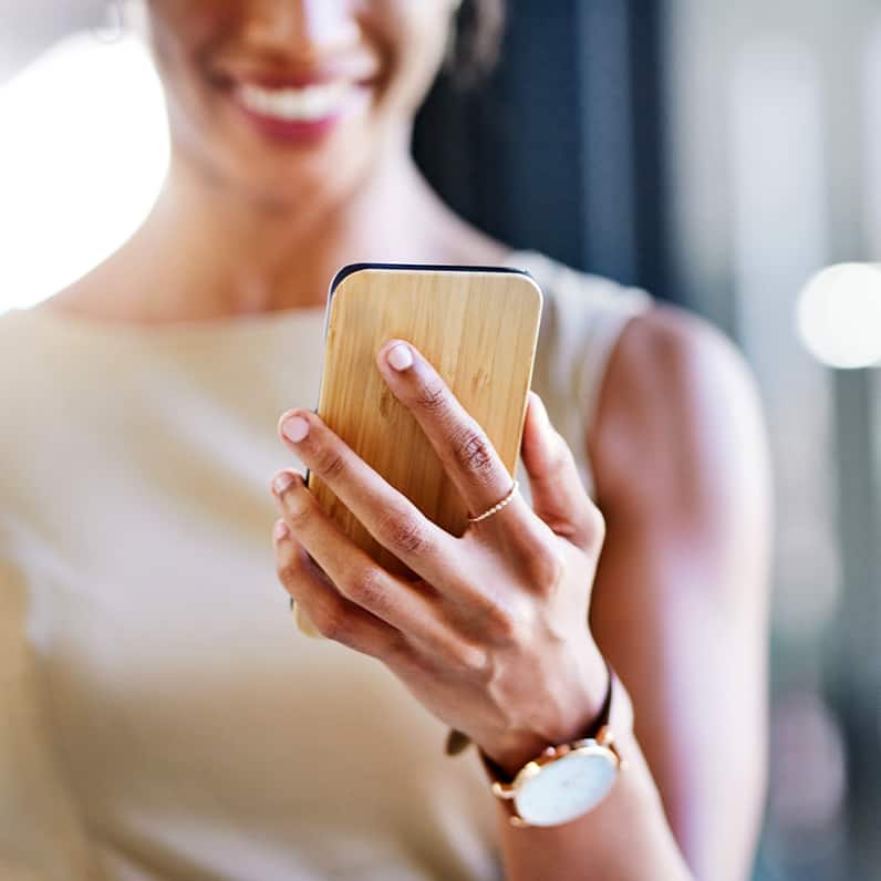 Woman laughing while looking at her mobile